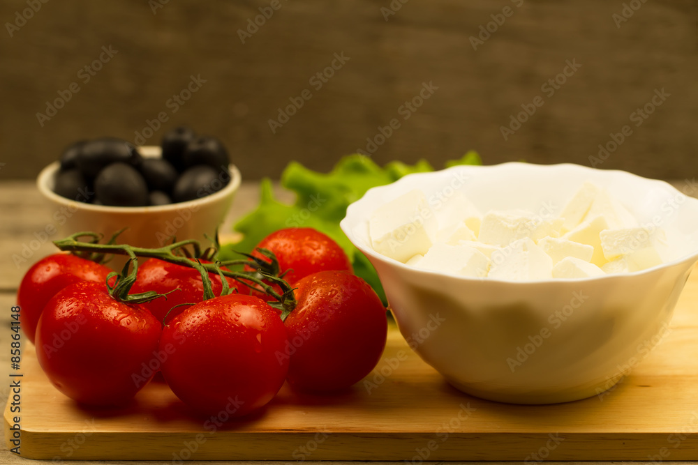 Home cooking summer Greek salad on wooden background Home cooking summer Greek salad on wooden background