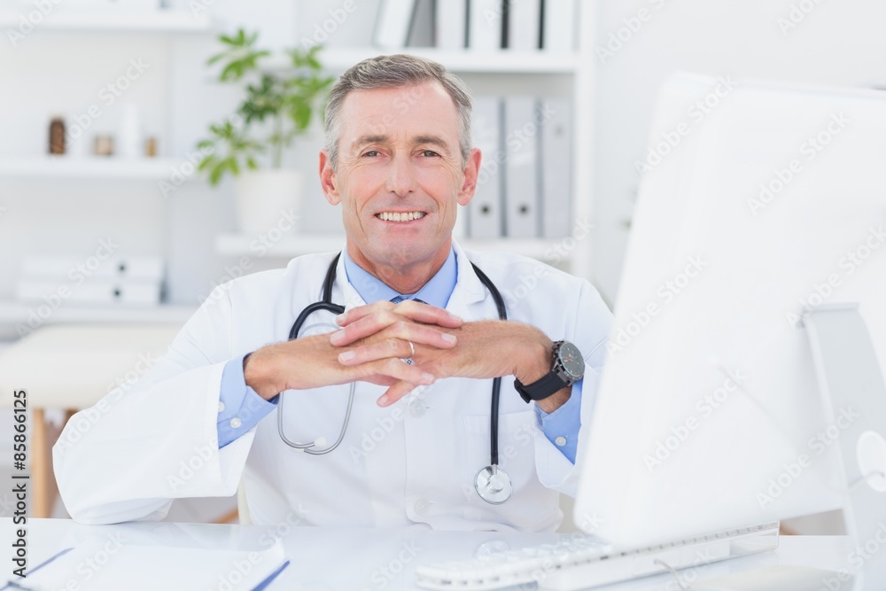 Smiling doctor looking at camera with hands crossed