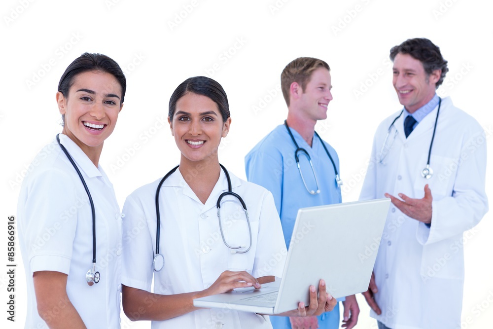 Doctors and nurses discussing and using laptop Doctors and nurses discussing and using laptop