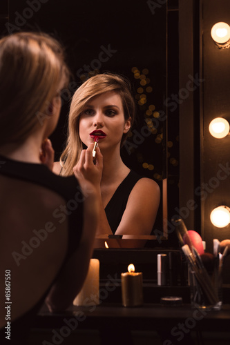 Girl applying red lipstick