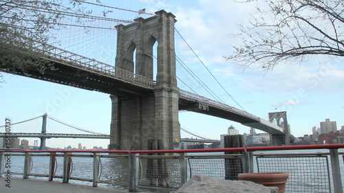 Brooklyn Bridge on a nice sunny spring day, one unrecognizable man jogging passing by