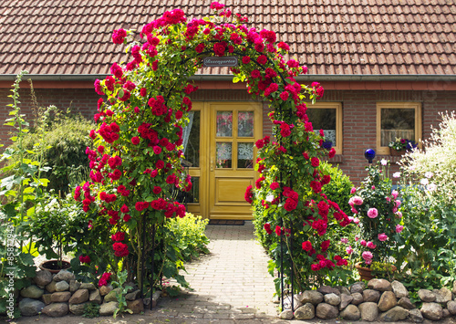 Romantischer Vorgarten mit Rosenbogen