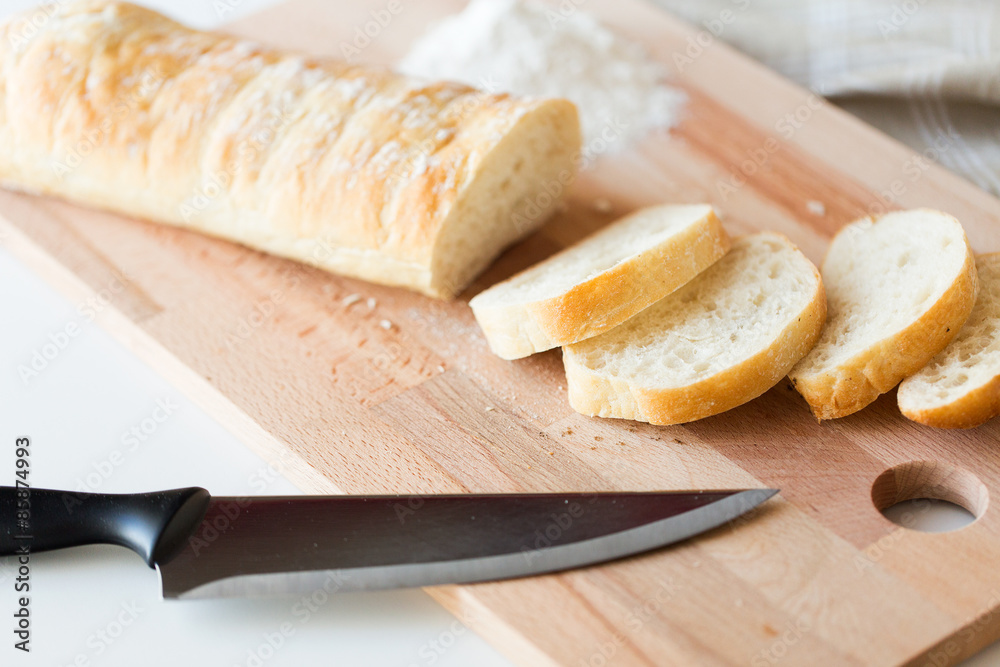 close up of white bread or baguette and knife