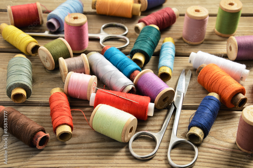 needle thread scissors on a wooden table needle thread scissors on a wooden table