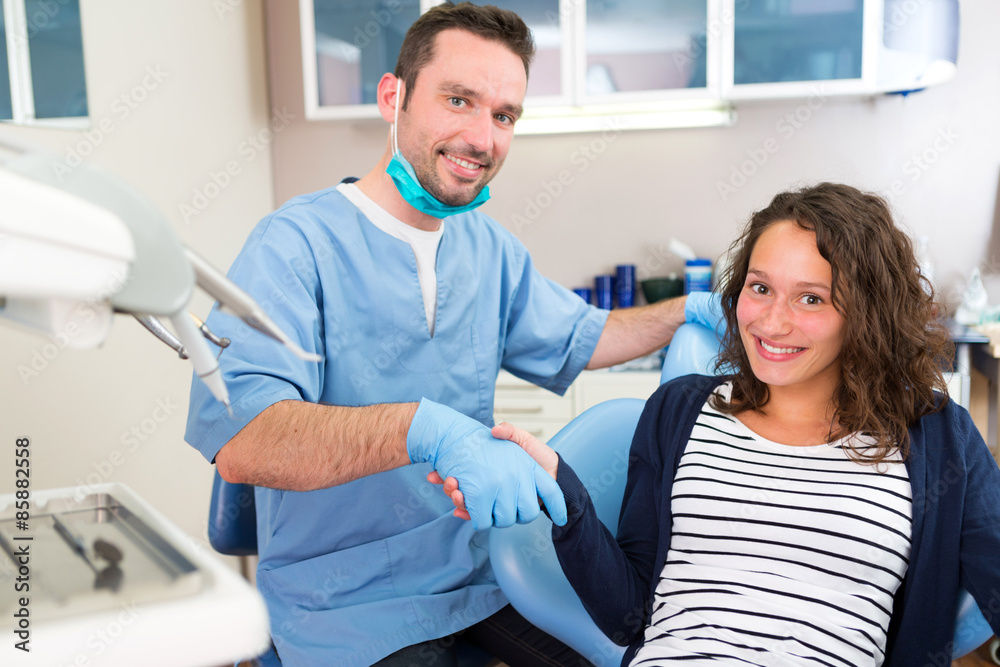 Young attractive dentist explaning his work to a patient Young attractive dentist explaning his work to a patient
