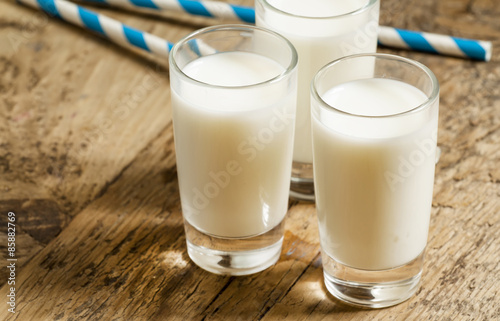 Three glasses of fresh milk on old wooden table in rustic style,