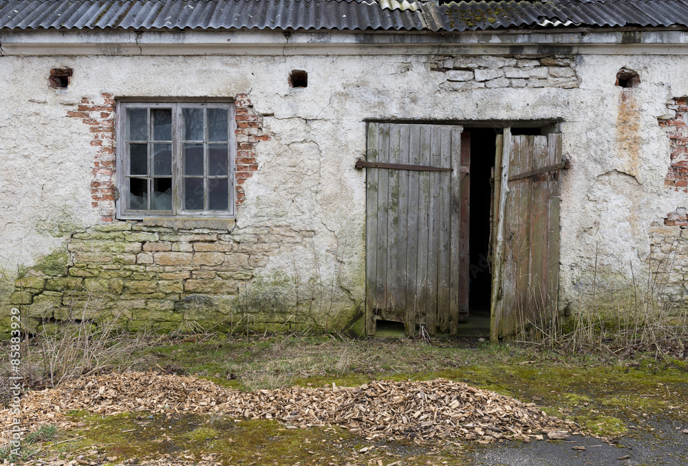 The old plastered limestone wall with a windows and a door The old plastered limestone wall with a windows and a door