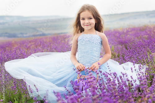 Happy little girl in lavender field with basket