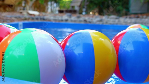 Colorful beach balls floating in pool.