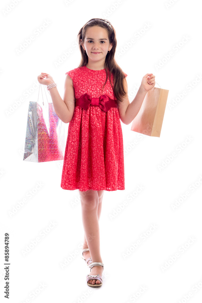 shopping concept - cute little girl with bags isolated on white background