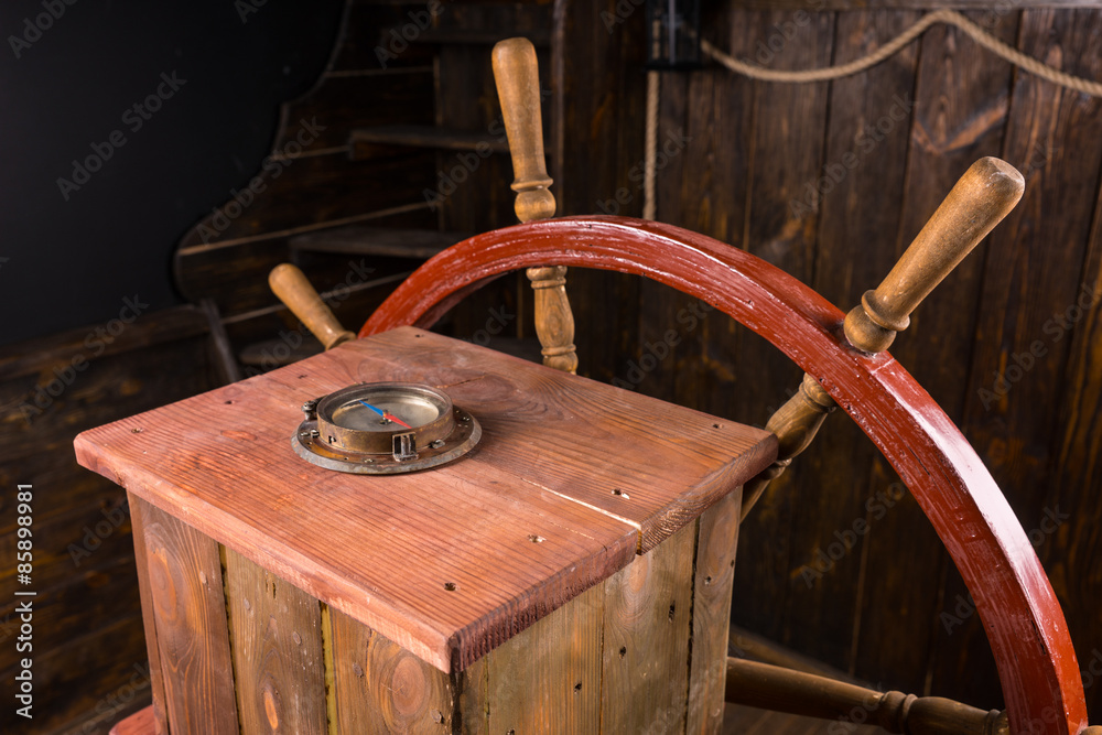 Old wooden ships wheel and compass