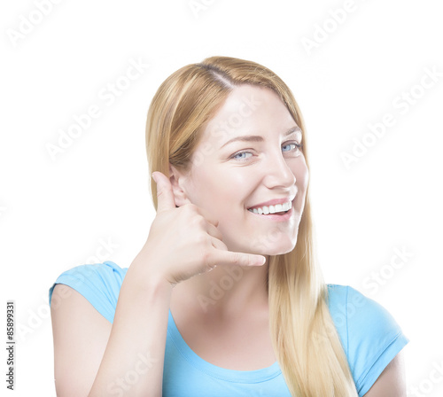 Blonde gesturing phone sign and smiling. Isolated on white.