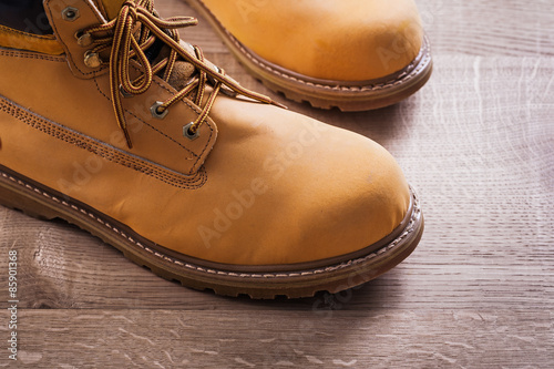 very close up view on pair of working boots wood board