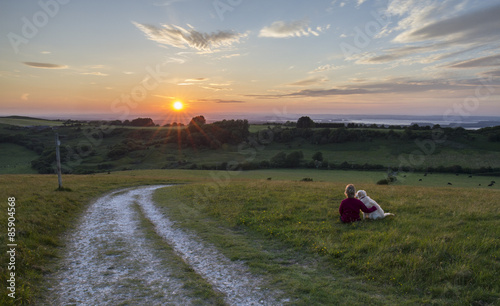 woman and dog enjoying sunset