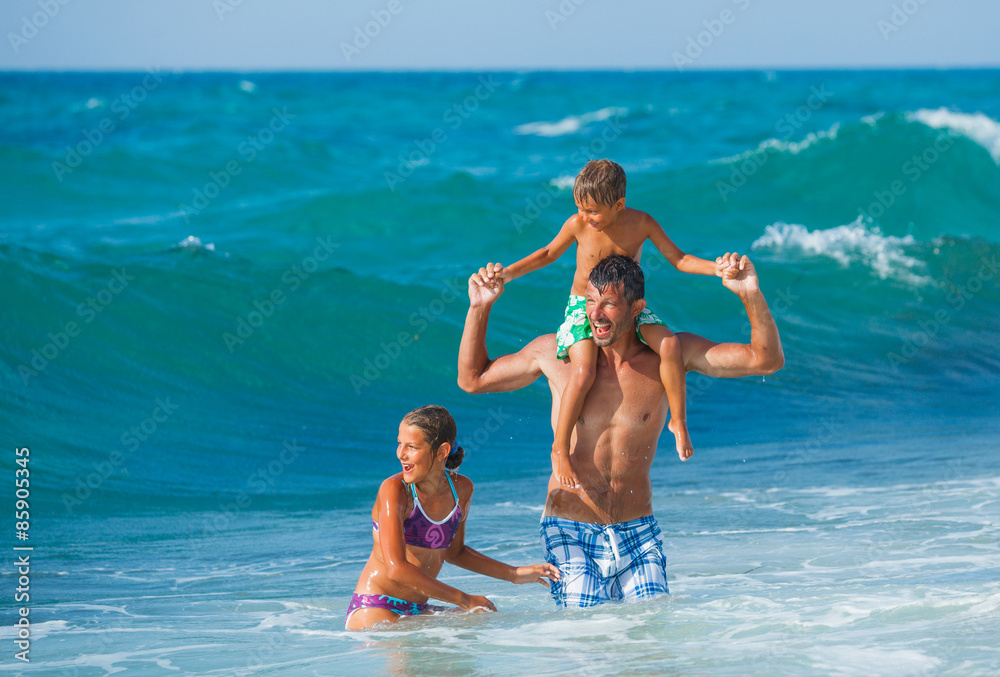 Father and children playing in the sea