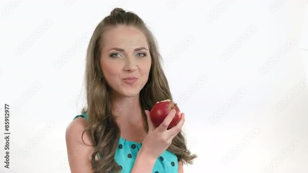 Beautiful girl eating an dark red apple - isolated over white Beautiful girl eating an dark red apple - isolated over white