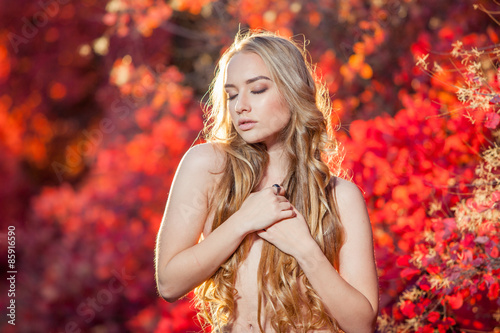 young woman on a background of red and yellow autumn leaves with