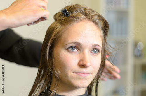 Friseur schneidet jungen Frau die Haare