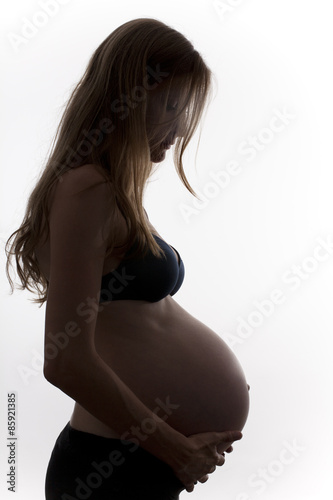 Mujer rubia embarazada sujetándose la barriga