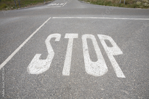 crossroads with stop signal painted on asphalt