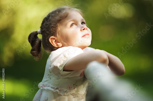 Schilderij op canvas Little happy beautiful girl looking up