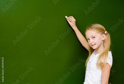 Schoolgirl wants to write something on the blackboard
