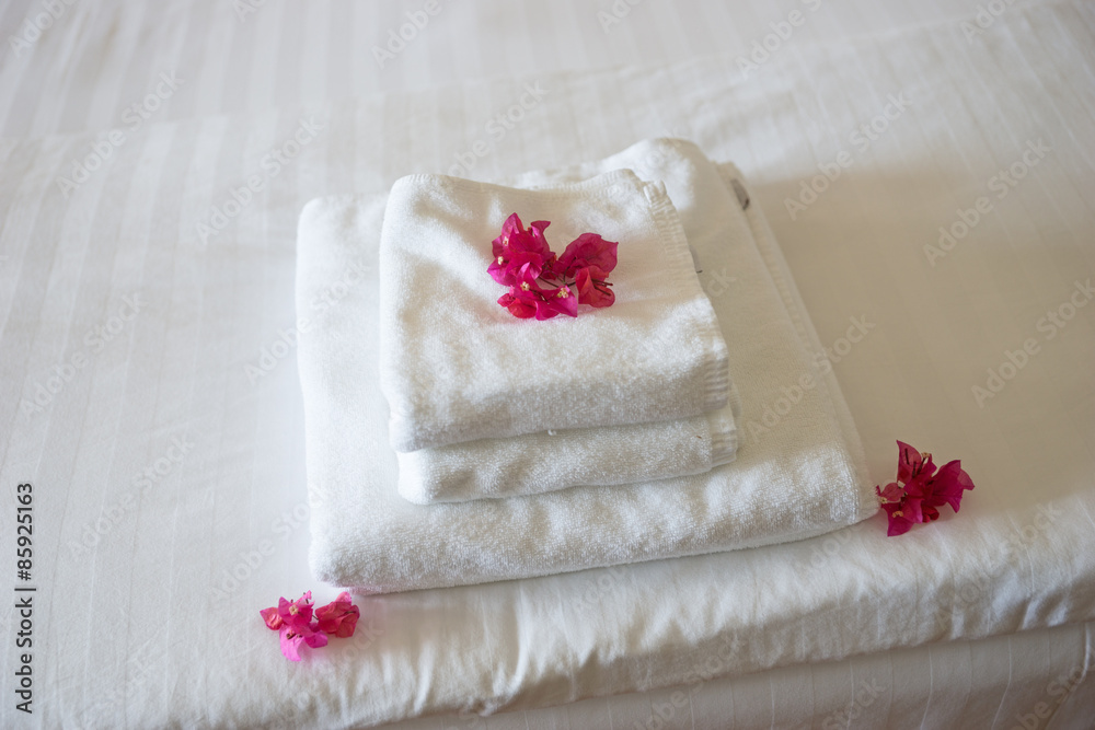 Frische Handtücher im Hotel, geschmückt mit Blüten Frische Handtücher im Hotel, geschmückt mit Blüten