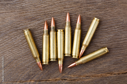 Bullets on rustic wooden background.