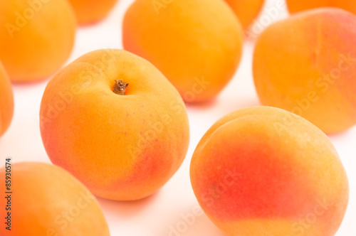 Single Apricot in Focus Amid Many Fresh Apricots in Diagonal Pattern