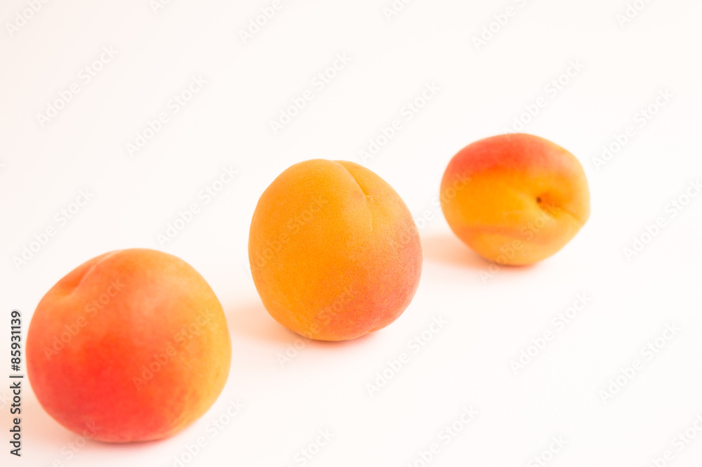 Close up of Three Soft Fresh Apricots Arranged Diagonally on a White Background Close up of Three Soft Fresh Apricots Arranged Diagonally on a White Background