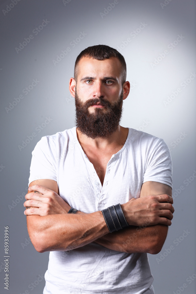 Portrait of handsome bearded man standing, isolated on grey Portrait of handsome bearded man standing, isolated on grey