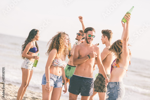 Canvas Print Multiracial group of friends having a party on the beach