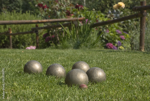 le bocce ,vicine al pallino rosso  sul prato di erba verde