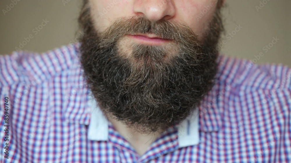 Bearded man eating sushi with a chopsticks
