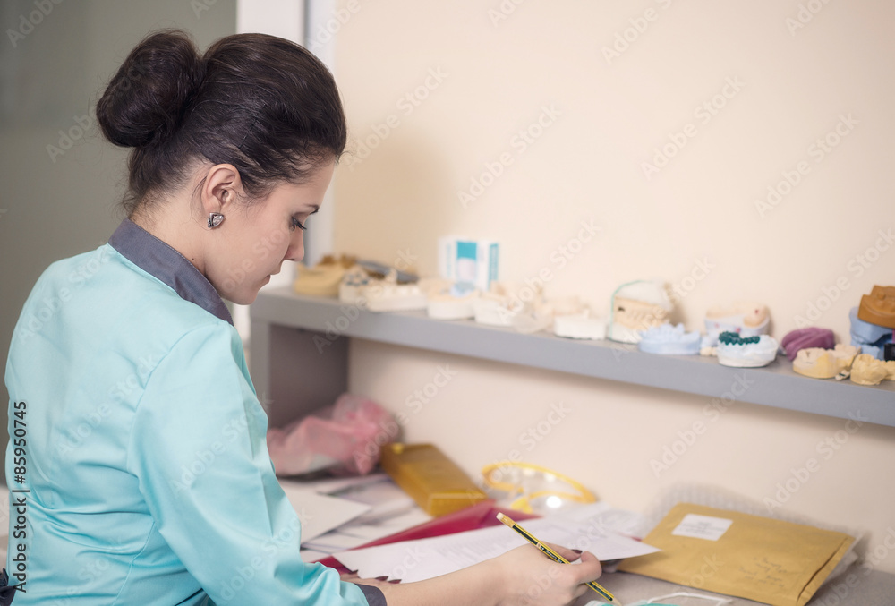 young girl sitting at the dentist table and writes young girl sitting at the dentist table and writes