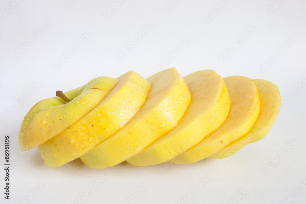 Single yellow apple cut into diagonal slices Single yellow apple cut into diagonal slices