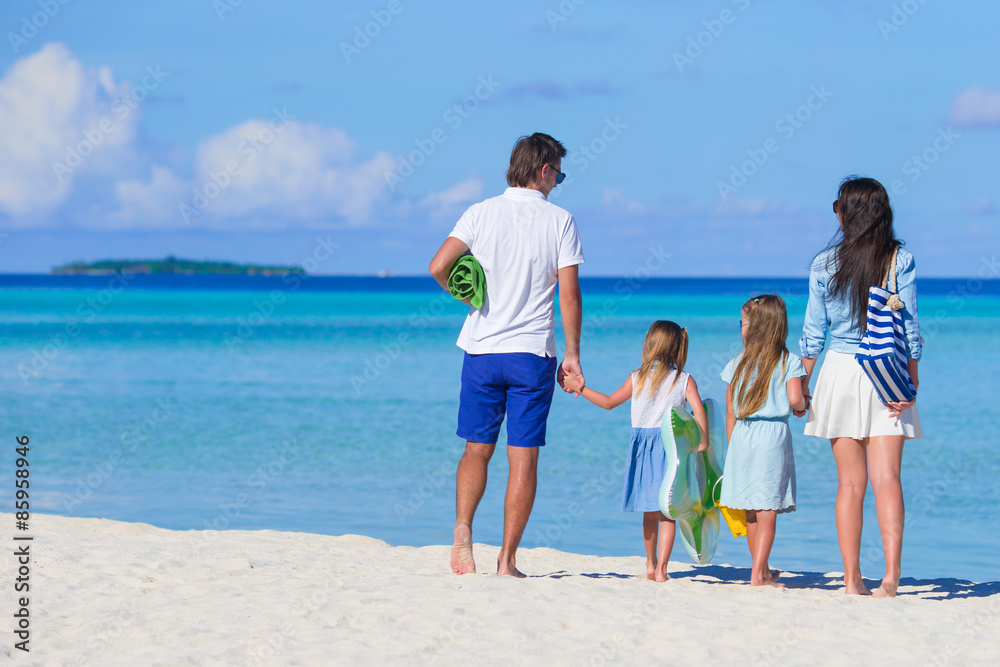 Young family on white beach during summer vacation