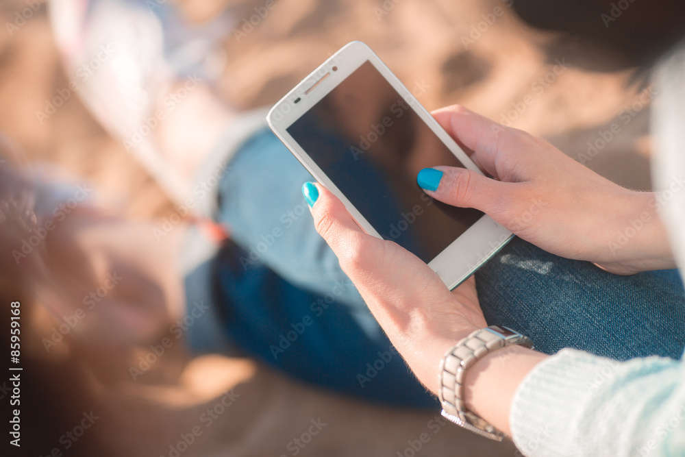 Beautiful girl on the beach with cellphone