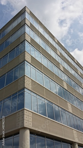 modern office building with clouds reflected in windows, corner angle
