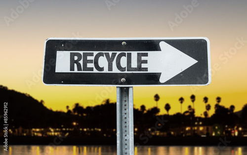 Recycle direction sign with sunset background