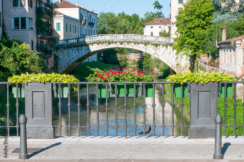 Flowered balcony of Saint Paul bridge in Vicenza, Retrone river and Saint Michele bridge in the background photo