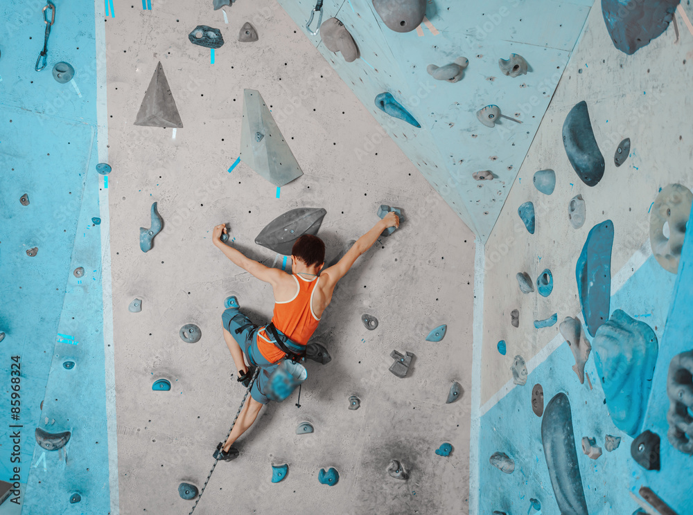 Boy in safety equipment climbing in gym StockFoto Adobe Stock