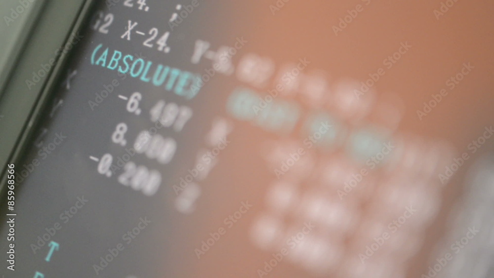 CNC machine monitor display with program code running and numbers with parameters changing 