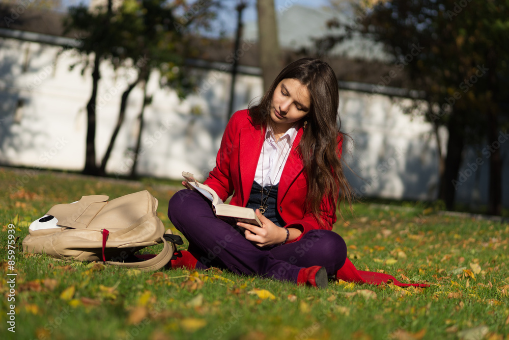 Student girl outside reading book. Caucasian college or universi Student girl outside reading book. Caucasian college or universi