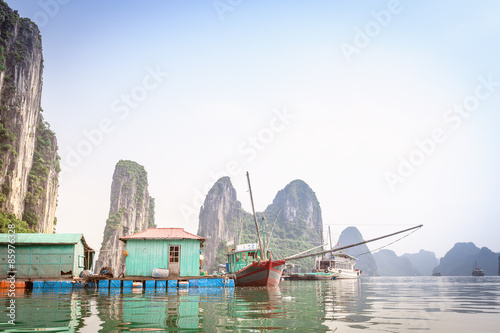 Fishermen's floating house on a background of mountains in Halong Bay in Vietnam
