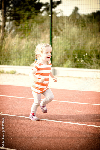 little girl running on the treadmill photo