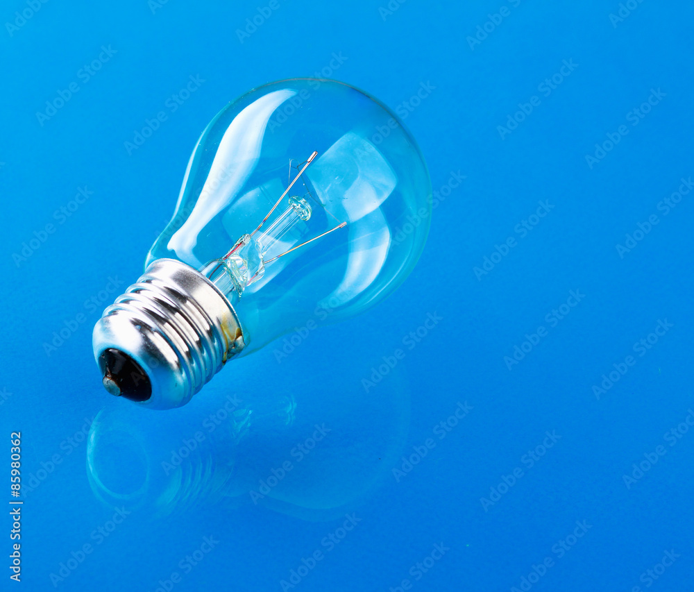 Light bulb isolated on blue glossy background Light bulb isolated on blue glossy background