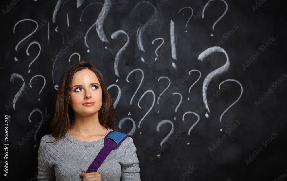 Young girl with question mark on a gray background Young girl with question mark on a gray background
