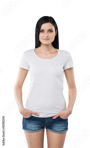 Brunette girl in a white t-shirt and denim shorts. Isolated on white. photo
