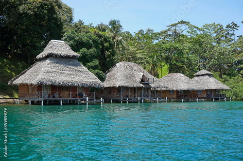Tropical resort with thatched bungalows over water
